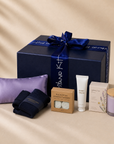 Code Calm nurse stress relief gift set in front of the signature Gitano Kit navy gift box — lavender eye pillow, compression socks, eucalyptus shower steamers, hand cream, herbal tea and lavender candle