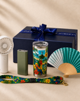 Sol & Samba summer stay-cool travel gift set with the real navy Gitano Kit gift box, satin ribbon, bow and silver script — handheld turbo fan, mini power bank, tropical Brazil tumbler, teal folding hand fan and lanyard on cream marble